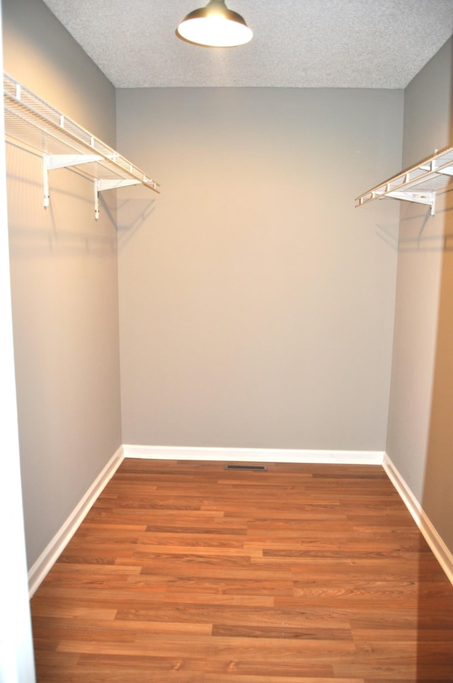 spacious closet featuring visible vents and wood finished floors