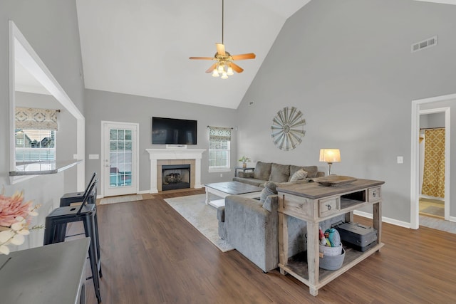 living area with visible vents, ceiling fan, a healthy amount of sunlight, and high vaulted ceiling