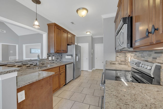 kitchen with a sink, appliances with stainless steel finishes, tasteful backsplash, and brown cabinetry