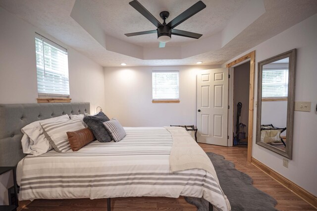 2281 Jefferson Rd, Smithville, TN 37166 - bedroom featuring baseboards, wood finished floors, a textured ceiling, and a tray ceiling