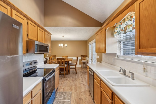 kitchen with backsplash, stainless steel appliances, lofted ceiling, and light countertops