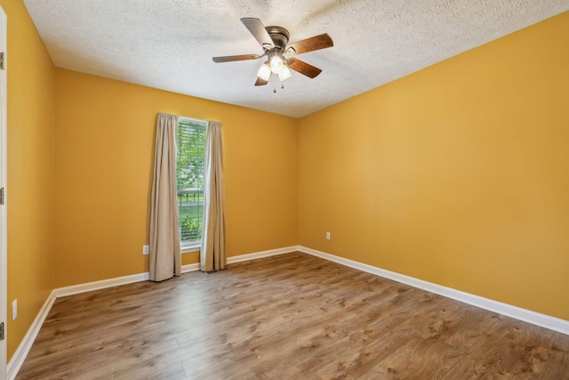 spare room with baseboards, a textured ceiling, ceiling fan, and wood finished floors