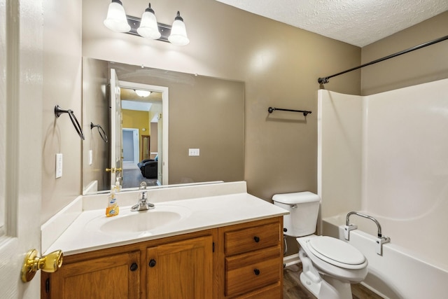 full bath featuring vanity,  shower combination, a textured ceiling, and toilet