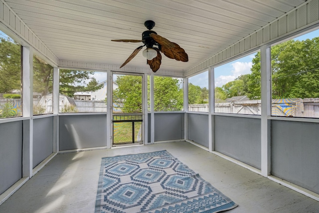 unfurnished sunroom featuring a ceiling fan