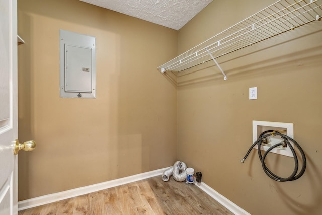 laundry area featuring washer hookup, laundry area, baseboards, wood finished floors, and electric panel