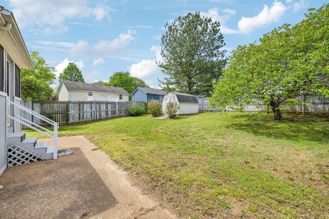 view of yard featuring an outdoor structure, a fenced backyard, and a shed
