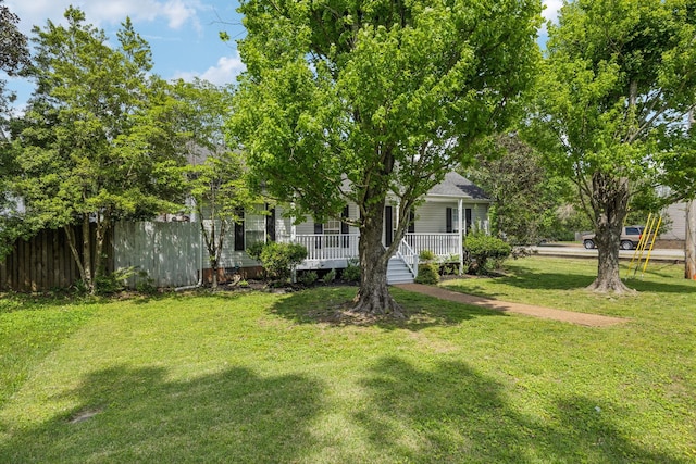 view of yard with covered porch and fence