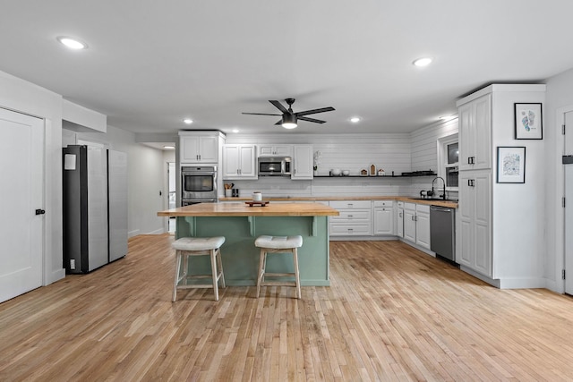 3055 Carters Creek Pike, Franklin, TN 37064 - kitchen featuring butcher block counters, appliances with stainless steel finishes, a sink, light wood finished floors, and ceiling fan