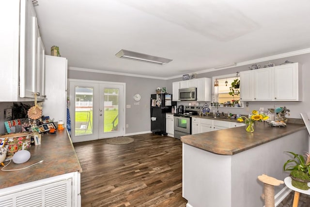 kitchen with white cabinets, appliances with stainless steel finishes, ornamental molding, dark wood-type flooring, and french doors