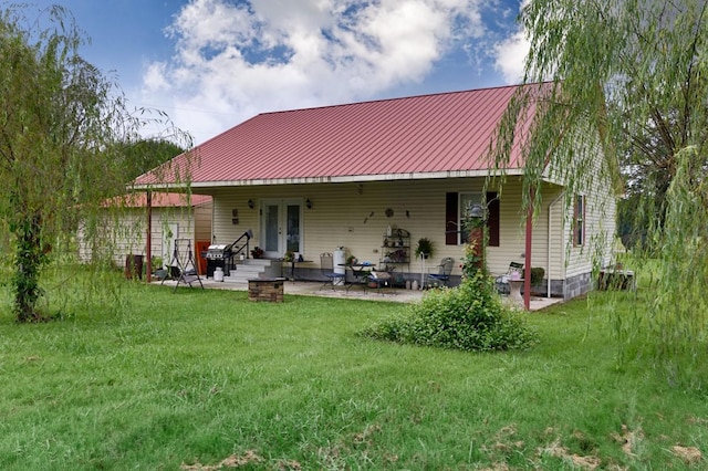 back of house with french doors, metal roof, a yard, and a patio area