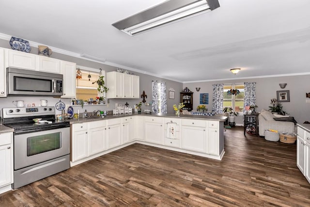 kitchen with white cabinetry, stainless steel appliances, dark wood-style floors, ornamental molding, and a peninsula