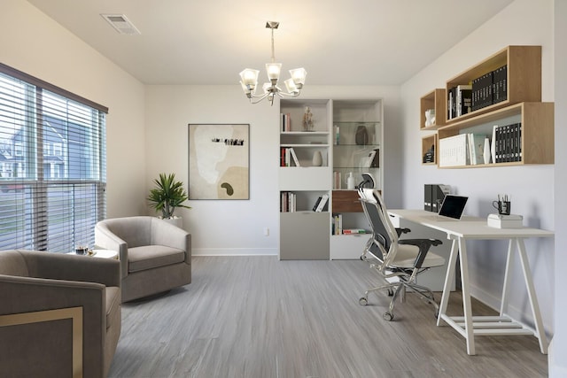 office space featuring a notable chandelier, baseboards, wood finished floors, and visible vents