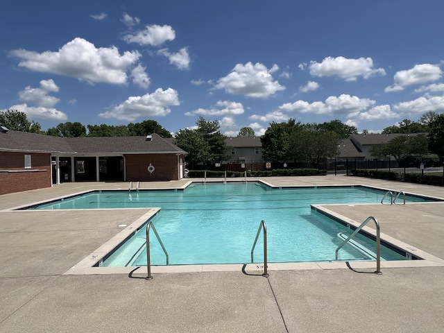 pool with a patio and fence