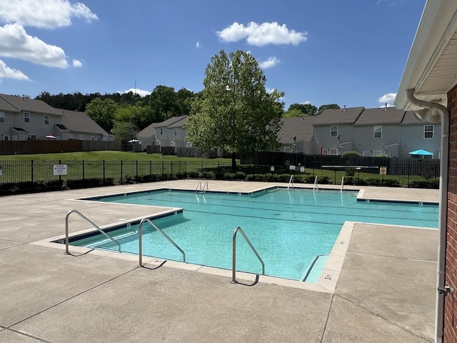 pool with a residential view, a patio, a lawn, and fence