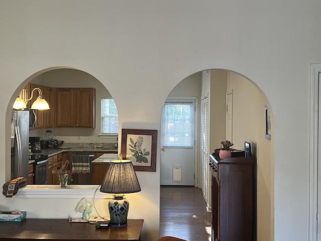 1101 Downs Blvd Unit K101, Franklin, TN 37064 - kitchen featuring stainless steel appliances, dark wood finished floors, arched walkways, and brown cabinets