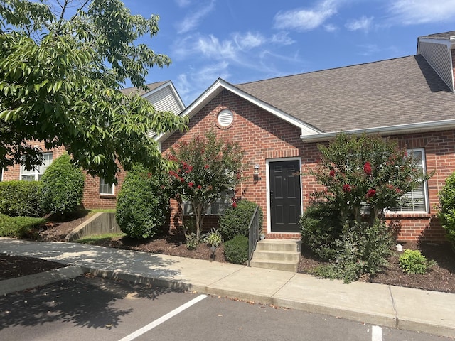 1101 Downs Blvd Unit K101, Franklin, TN 37064 - view of front facade featuring brick siding, a shingled roof, uncovered parking, and entry steps