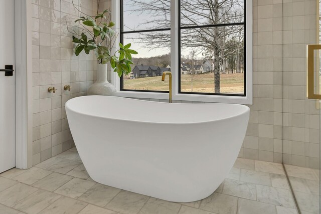 7091 Anna Dr, Brentwood, TN 37027 - bathroom featuring a wealth of natural light, marble finish floor, and tile walls