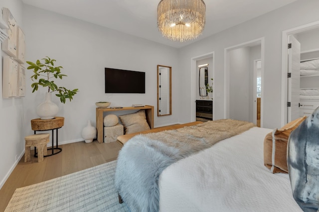 7091 Anna Dr, Brentwood, TN 37027 - bedroom with connected bathroom, a notable chandelier, wood finished floors, and baseboards