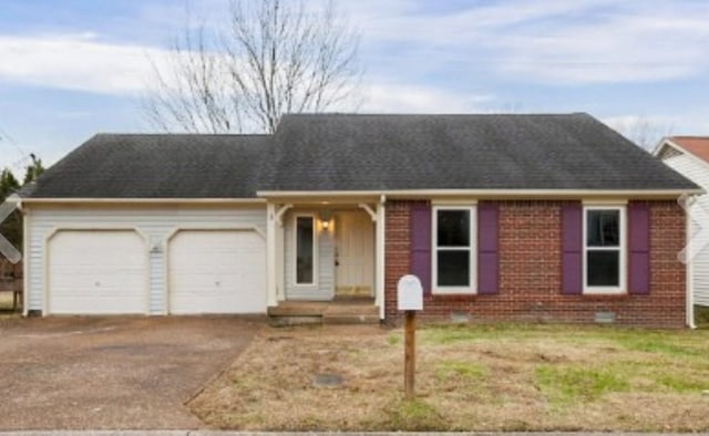 single story home with driveway, brick siding, and a garage