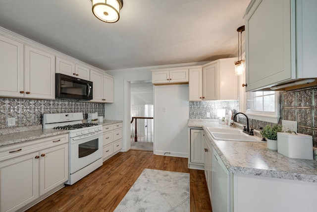 kitchen featuring tasteful backsplash, white appliances, dark wood-style flooring, and a sink