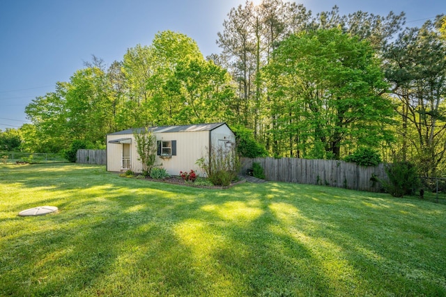 view of yard featuring a storage unit, an outbuilding, and a fenced backyard