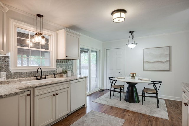 kitchen with a sink, decorative backsplash, pendant lighting, dishwasher, and dark wood finished floors
