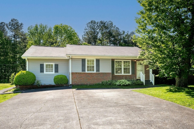 ranch-style home with a front lawn, concrete driveway, and brick siding