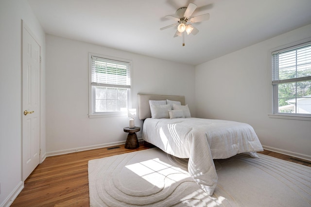 bedroom featuring visible vents, wood finished floors, and multiple windows