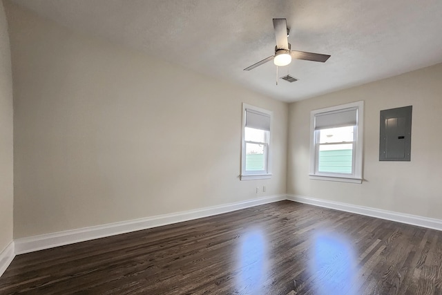 unfurnished room with dark wood-type flooring, electric panel, and baseboards