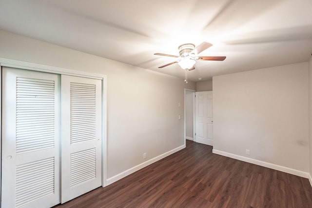 unfurnished bedroom with a closet, baseboards, ceiling fan, and dark wood finished floors