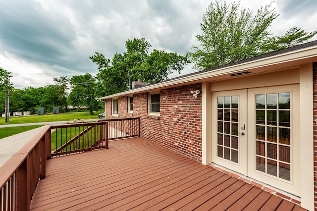 wooden deck with french doors and a yard