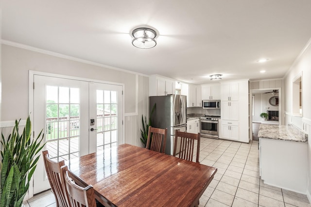 dining area with crown molding, french doors, and light tile patterned flooring