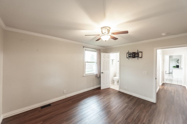 spare room featuring ceiling fan, ornamental molding, dark wood-type flooring, and visible vents