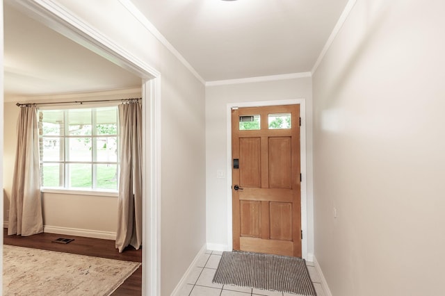 entrance foyer with crown molding, baseboards, a wealth of natural light, and visible vents