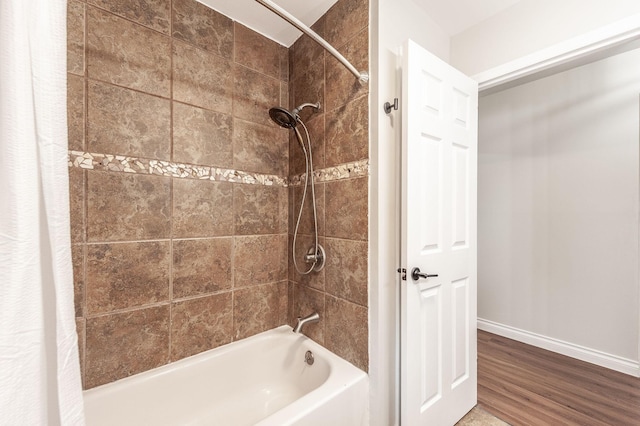 bathroom with baseboards, wood finished floors, and shower / bath combination with curtain
