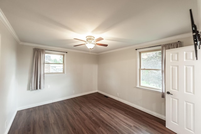 spare room featuring crown molding, baseboards, ceiling fan, and dark wood finished floors