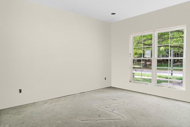 empty room with a wealth of natural light and concrete flooring