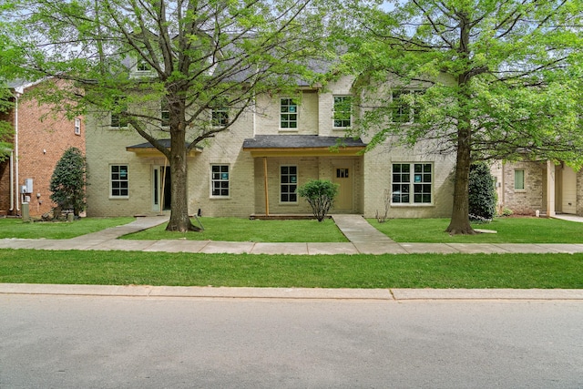 view of front of house featuring a front yard and brick siding