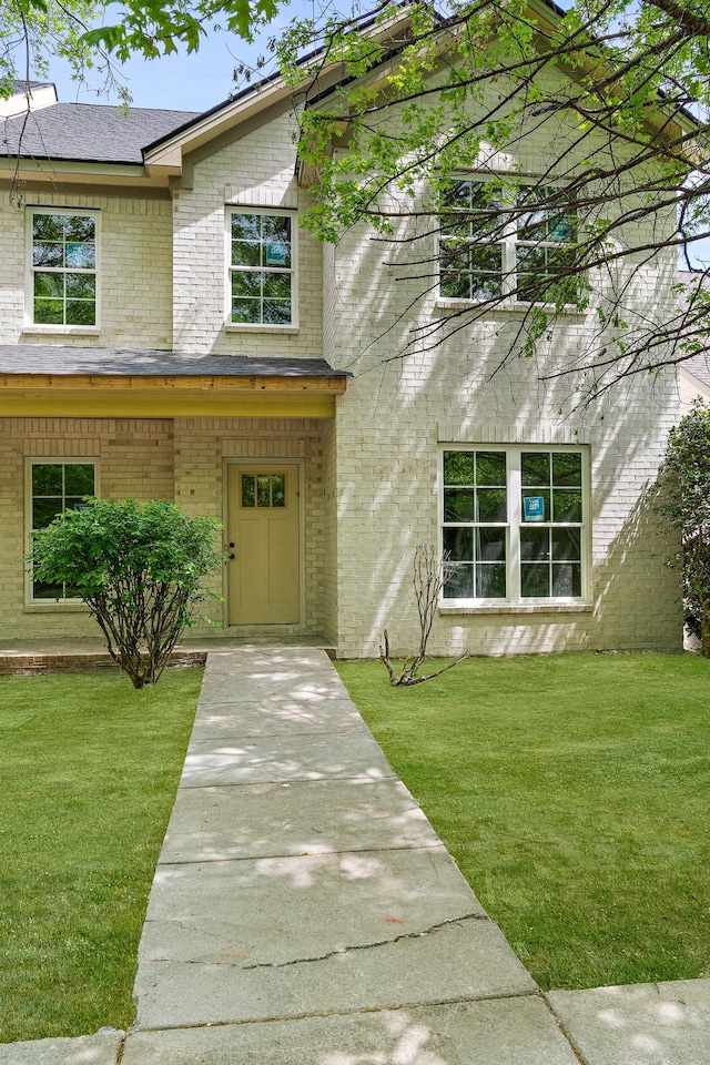 view of front of home with a front lawn and brick siding