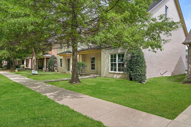 view of front of house with a front yard and brick siding