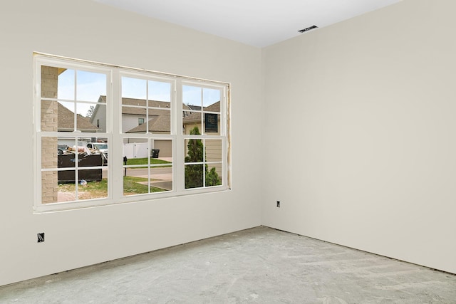 empty room featuring unfinished concrete flooring and a healthy amount of sunlight