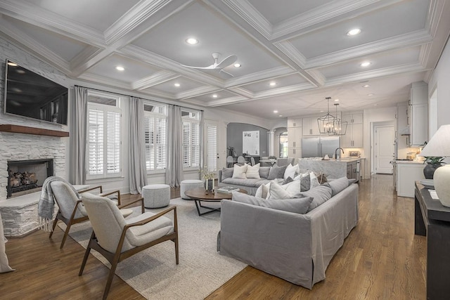 9710 Onyx Ln, Brentwood, TN 37027 - living area featuring ornamental molding, wood finished floors, a fireplace, arched walkways, and coffered ceiling