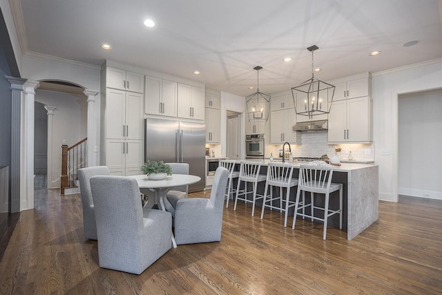 9710 Onyx Ln, Brentwood, TN 37027 - dining area featuring ornamental molding, decorative columns, dark wood-style flooring, baseboards, and recessed lighting