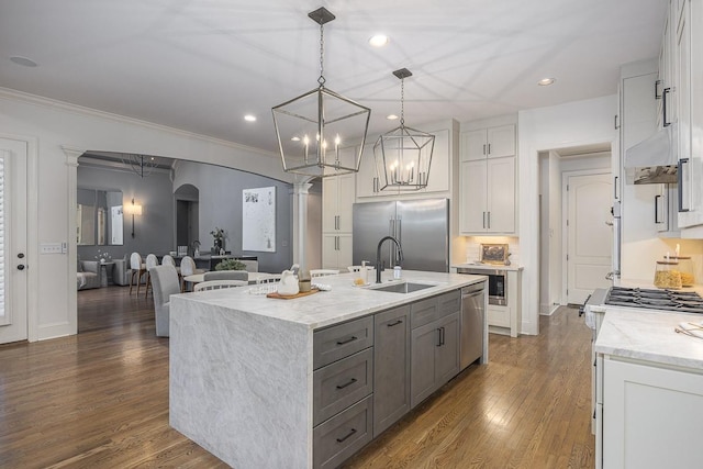 9710 Onyx Ln, Brentwood, TN 37027 - kitchen with appliances with stainless steel finishes, a sink, light stone counters, dark wood-style floors, and white cabinetry
