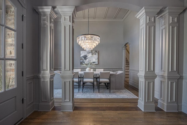 9710 Onyx Ln, Brentwood, TN 37027 - dining space featuring decorative columns, a decorative wall, a chandelier, arched walkways, and dark wood finished floors