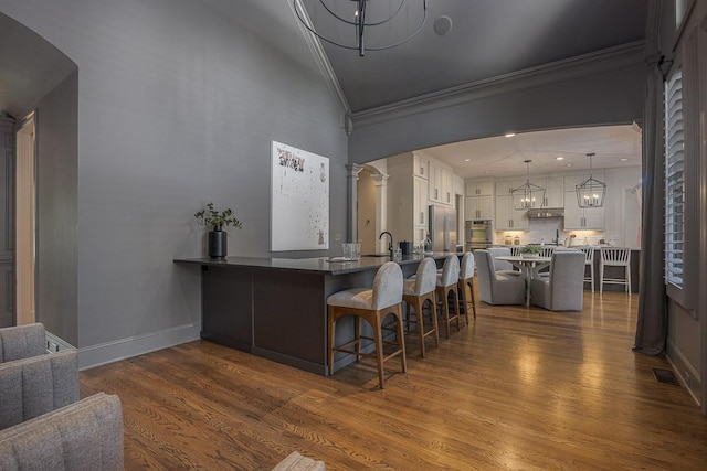 9710 Onyx Ln, Brentwood, TN 37027 - bar with decorative backsplash, dark wood-style flooring, visible vents, an inviting chandelier, and ornamental molding