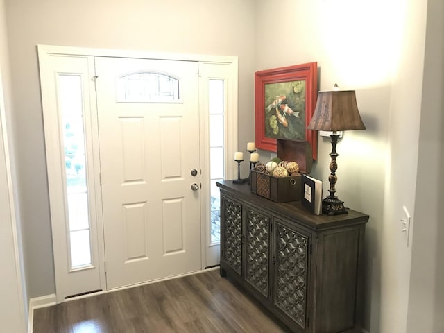 entryway with dark wood-style flooring and baseboards