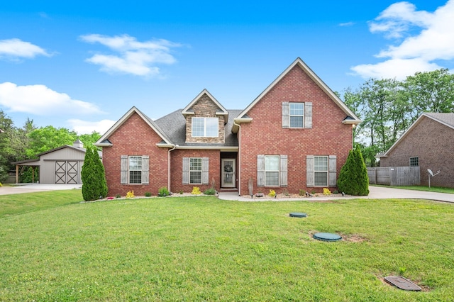 traditional-style house with brick siding, a front lawn, an outbuilding, and driveway