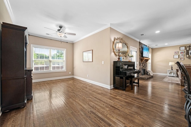 living room with a ceiling fan, visible vents, baseboards, dark wood-style floors, and ornamental molding