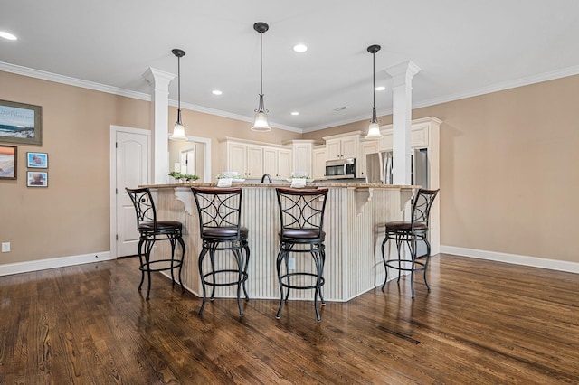 kitchen with baseboards, a breakfast bar area, stainless steel appliances, and dark wood-style floors